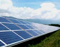 A large solar panel sitting on top of a green field.